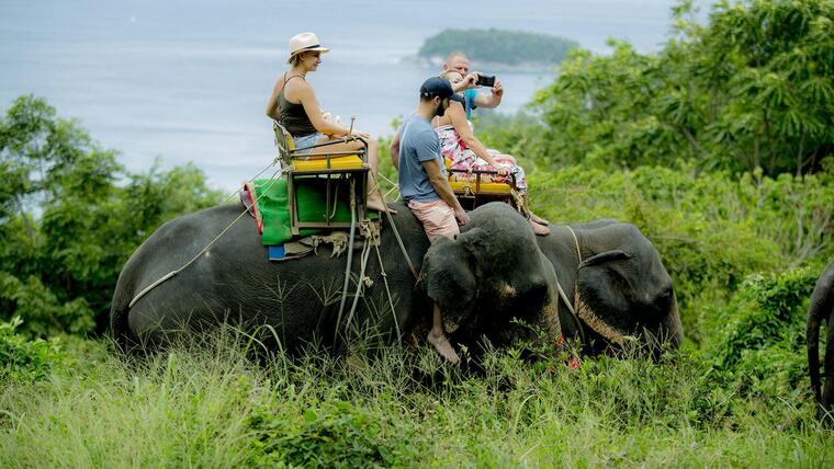 Двое туристов на слоне на холме Kok Chang Safari, внизу море и остров