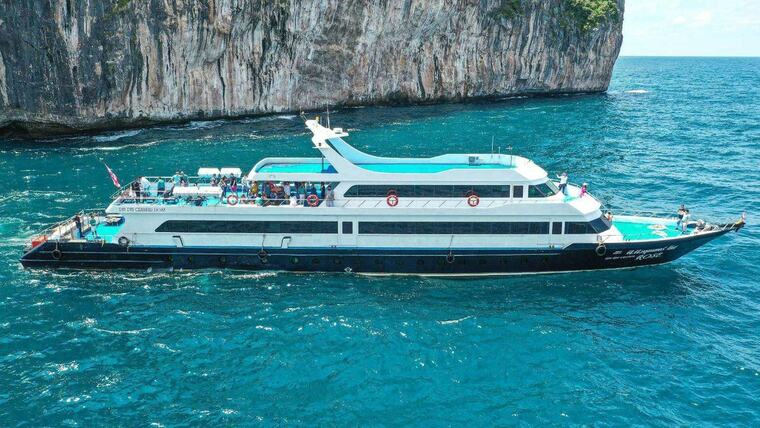 Паром Phi Phi Cruiser с пассажирами на палубах идёт вдоль отвесных скал Пхи-Пхи