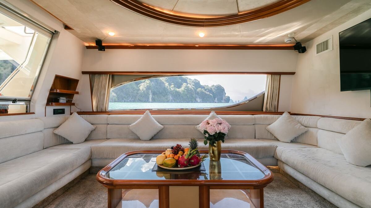 Салон яхты Ferretti 80 Sofia: светлые диваны, столик с фруктами и окна на море