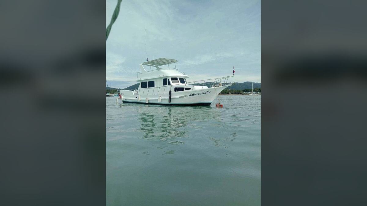 Белая моторная яхта для морской рыбалки на якоре в спокойной бухте