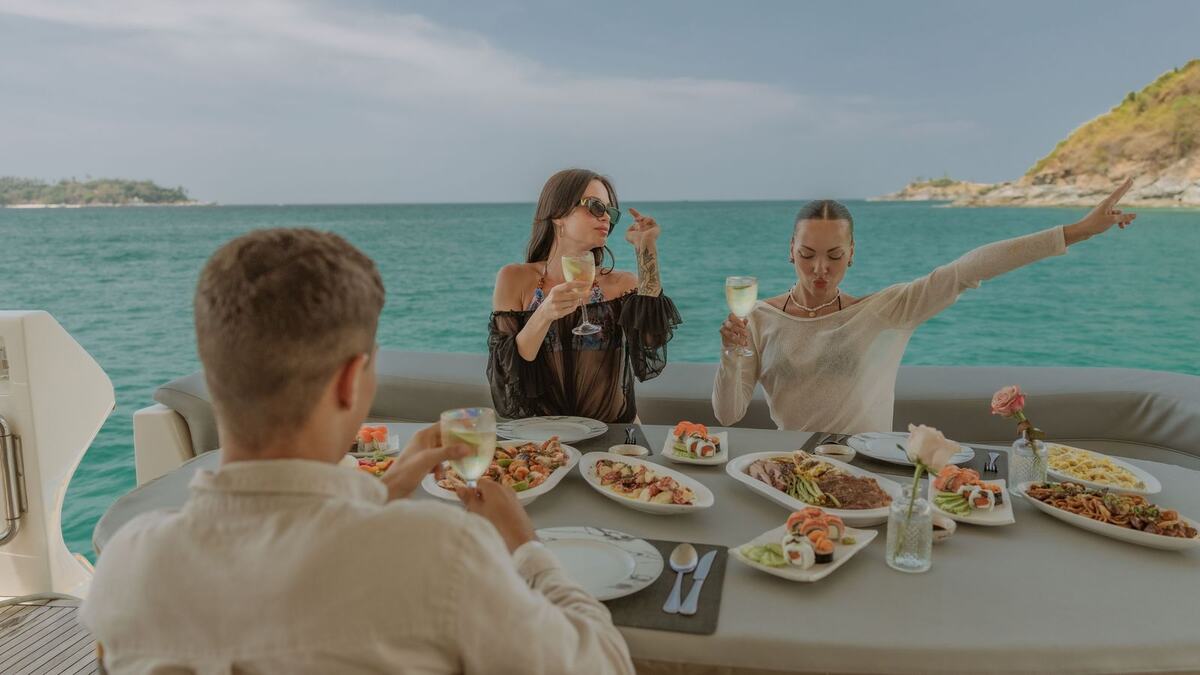 Обед на корме яхты Say Yes: гости за накрытым столом с видом на море